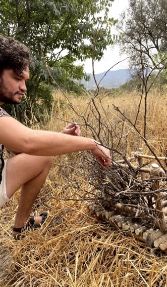 Nest sculpture built with dried lemon branches containing a small water pool